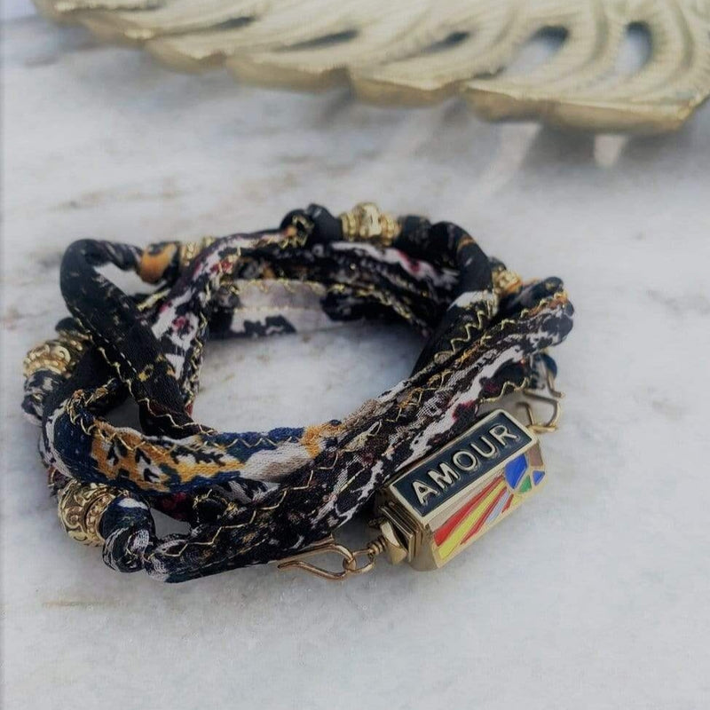 Cordon en soie de sari recyclé evasion coloris cachemire, présenté avec le pendentif peace and love noir, en version bracelet 5 tours