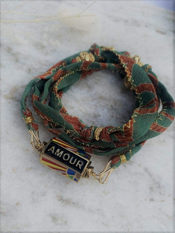 Cordon en soie de sari recyclé marron vert présenté en version bracelet 5 tours agrémenté du pendentif peace and love de la collection